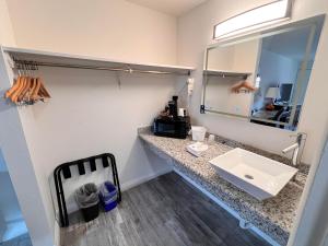 a bathroom with a sink and a mirror at Howard Johnson by Wyndham Downtown Reno in Reno