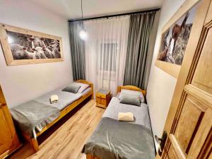 a room with two beds and a door at Apartamenty Nad Dunajcem koło Zakopanego in Biały Dunajec +75 photos