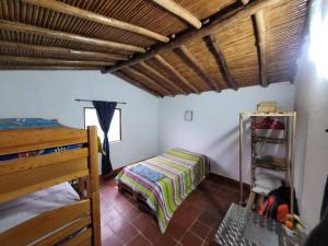 1 dormitorio con 1 cama y 1 dormitorio con litera y escalera en Cabaña Caprichito, en Piedecuesta