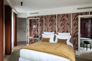 - une chambre avec un grand lit et un mur marron dans l'établissement Hotel Florida Paris, à Paris