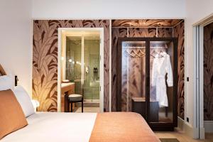 a bedroom with a bed and a walk in shower at Hotel Florida Paris in Paris