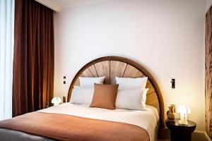 a bedroom with a large bed with a wooden headboard at Hotel Florida Paris in Paris