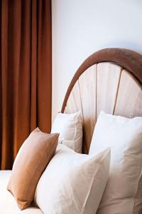 a bed with white pillows and a wooden headboard at Hotel Florida Paris in Paris +77 photos
