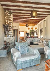 uma sala de estar com sofás azuis e uma parede de pedra em DMN - Dar Mama Noufissa 