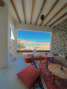 uma sala de estar com uma mesa e uma grande janela em DMN - Dar Mama Noufissa 