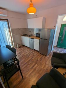 cocina y sala de estar con mesa y nevera en Apartments Magnolija 50m from beach en Srima