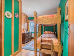 5 Bed in Eskdale SZ259 في إسكاديل: غرفة نوم مع سرير بطابقين وجدار أخضر