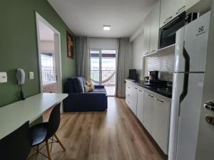 Il comprend un salon et une cuisine équipée d'un réfrigérateur. dans l'établissement FLAT COM VISTA INCRIVEL EM CONDOMINIO DE LUXO, à São Paulo