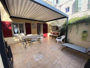 a patio with a table and chairs and awning at Résidence -bandol - Maisons & Villas 974 in Bandol