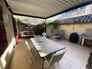 a table and chairs on a patio with an umbrella at Résidence 665-bandol - Magnifique Rez de villa T1 bis à Bandol MAE-0974 in Bandol
