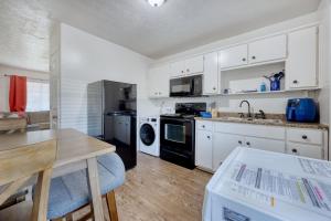 a kitchen with white cabinets and a wooden table at Southern Charm in Columbus
