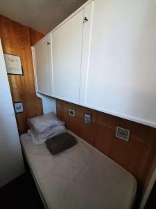 Habitación pequeña con cama y armario en Résidence Chabrieres - Studio pour 4 Personnes 134, en Risoul