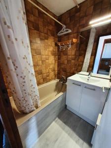 y baño con bañera, lavamanos y ducha. en Résidence Chabrieres - Studio pour 4 Personnes 134, en Risoul