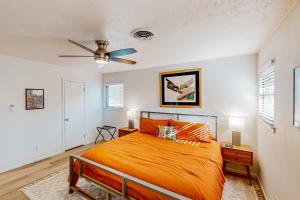 a bedroom with an orange bed and a ceiling fan at Mid-Century Memories in Lubbock