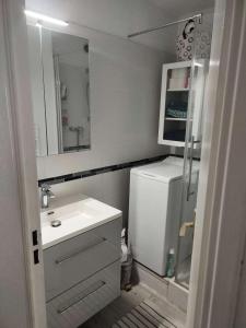 een witte badkamer met een wastafel en een spiegel bij Résidence Tartane - 2 Pièces pour 6 Personnes 674 in Six-Fours-les-Plages