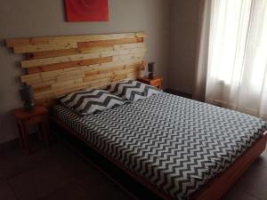 Bett mit einem Kopfteil aus Holz in einem Schlafzimmer in der Unterkunft Résidence Mistral - 4 Pièces pour 7 Personnes 514 in Six-Fours-les-Plages