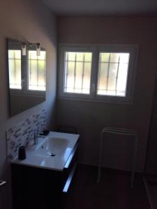 ein Badezimmer mit einem weißen Waschbecken und zwei Fenstern in der Unterkunft Résidence Mistral - 4 Pièces pour 7 Personnes 514 in Six-Fours-les-Plages