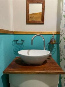 La salle de bains est pourvue d'un lavabo blanc sur un comptoir en bois. dans l'établissement Alojamiento La Casita de Lunlunta, Maipú, Mendoza, à Maipú