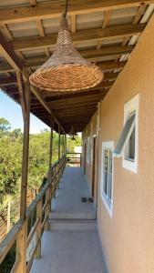 a wooden walkway with awning and a wicker ceiling at Vila do Rosa in Praia do Rosa