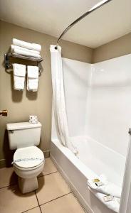a bathroom with a toilet and a bathtub with a shower curtain at Travelodge by Wyndham Reno in Reno +29 photos