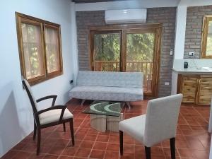 a living room with a bench and two chairs at Nueva Tierra, Ayampe in Las Tunas
