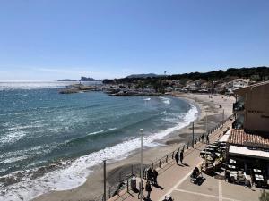 una spiaggia con persone che camminano sulla sabbia e sull'oceano di Résidence Oustalet - T2 Panoramique sur la mer à St Cyr Sur mer MAE-2824 a Les Lecques Altre 3 foto