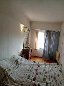 Schlafzimmer mit einem Bett und einem Fenster in der Unterkunft Apartment Tsentr 5 in Taschkent