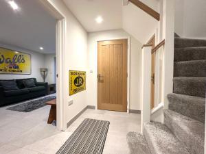 uma sala de estar com uma escada e uma porta de madeira em Modern 2 bedroom property with quirky décor em Chilcompton