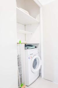 a washer and dryer in a white laundry room at SUNLIGHT HORIZON* Parking * Terrasse * Vue Mer * WIFI *Famille in La Grande Motte