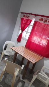 洛馬斯德薩莫拉的住宿－Hostel Dakini Lomas，窗户客房内的一张木桌和椅子