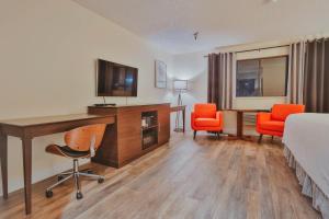 a hotel room with a bed and a desk and chairs at Hotel International in Lynnwood