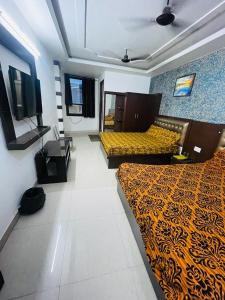 a hotel room with two beds and a television at The Boston Rooms in Agra