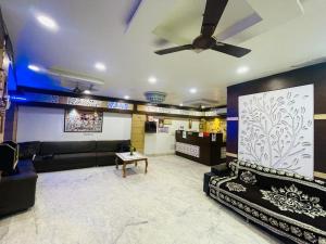 sala de estar con sofá y ventilador de techo en The Boston Rooms en Agra