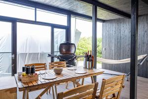 a dining room with a table and chairs and windows at THE GLAMPING PLAZA 伊勢志摩BASE in Ugata