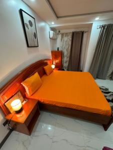 a bedroom with a bed with an orange bedspread at Dal Ak jamm in Guediawaye
