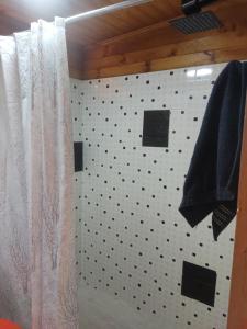 a bathroom with a black and white tiled wall at El Cabañazo in Villa de Leyva