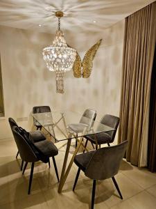 a dining room with a chandelier and a glass table and chairs at Soho West End in London