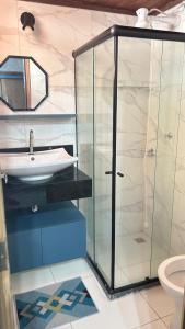 uma casa de banho com uma cabina de duche em vidro e um lavatório. em Maresia 7B em Salvador