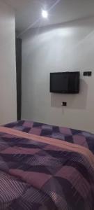 een slaapkamer met een bed en een flatscreen-tv aan de muur bij Humsidcy Hub in Lagos