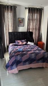 ein Schlafzimmer mit einem Bett mit einer lila und blauen Bettdecke in der Unterkunft Humsidcy Hub in Lagos