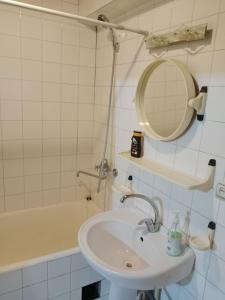 a bathroom with a sink and a mirror and a tub at Apartment Tsentr 5 in Tashkent