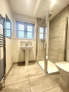 uma casa de banho com um lavatório e um chuveiro em Modern 2 bedroom property with quirky décor em Chilcompton