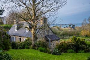 a stone house with a tree in a field at Résidence Ty Gouermel-plougrescant - Maisons & Villas pour 5 Personnes 854 in Lannion