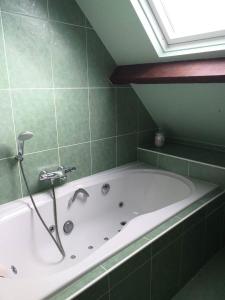 La salle de bains verte est pourvue d'une baignoire et d'une fenêtre. dans l'établissement Résidence 620-pleneuf Val Andre - Belle maison néo-bretonne dans un quartier résidentiel sur les hauteurs du Val André MAE-7614, à Pléneuf-Val-André