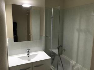 une salle de bain avec un lavabo et une douche avec un miroir dans l'établissement Résidence Les Bains - Charmant T3 à deux pas de la plage du Val André. MAE-6644, à Pléneuf-Val-André
