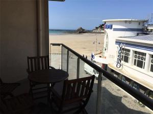 un balcon avec une table, des chaises et un bateau dans l'établissement Résidence Les Bains - Charmant T3 à deux pas de la plage du Val André. MAE-6644, à Pléneuf-Val-André