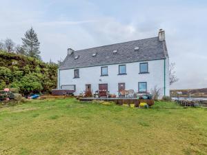 a large white house sitting on top of a field at 1 Bed in Badachro CA357 in Strath