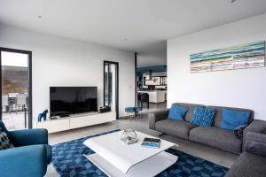 sala de estar con sofá y TV en Résidence Agapanthes-pleumeur Bodou - Maisons & Villas pour 12 Personnes 704, en Pleumeur-Bodou