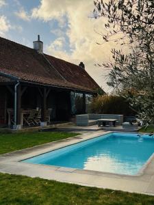 una piscina en el patio de una casa en ZEN Op Vakantie @vakantiehoeve met zwembad en Lierde