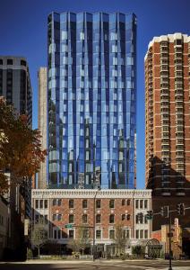 um edifício de vidro alto no topo de um edifício de tijolos em Viceroy Chicago em Chicago